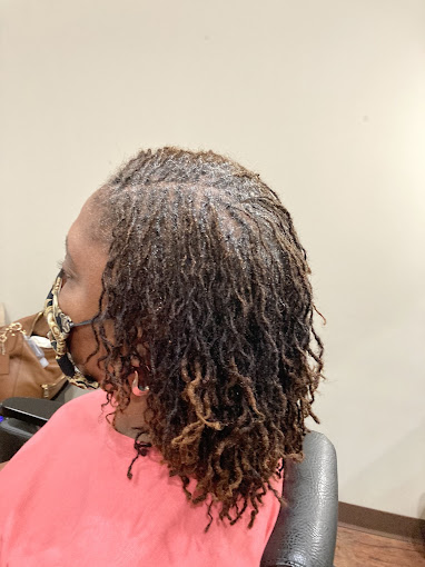 A woman sitting in a chair getting her hair cut