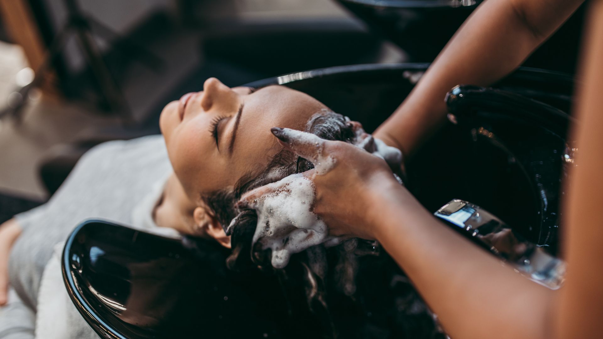A woman getting her hair washed in a salon